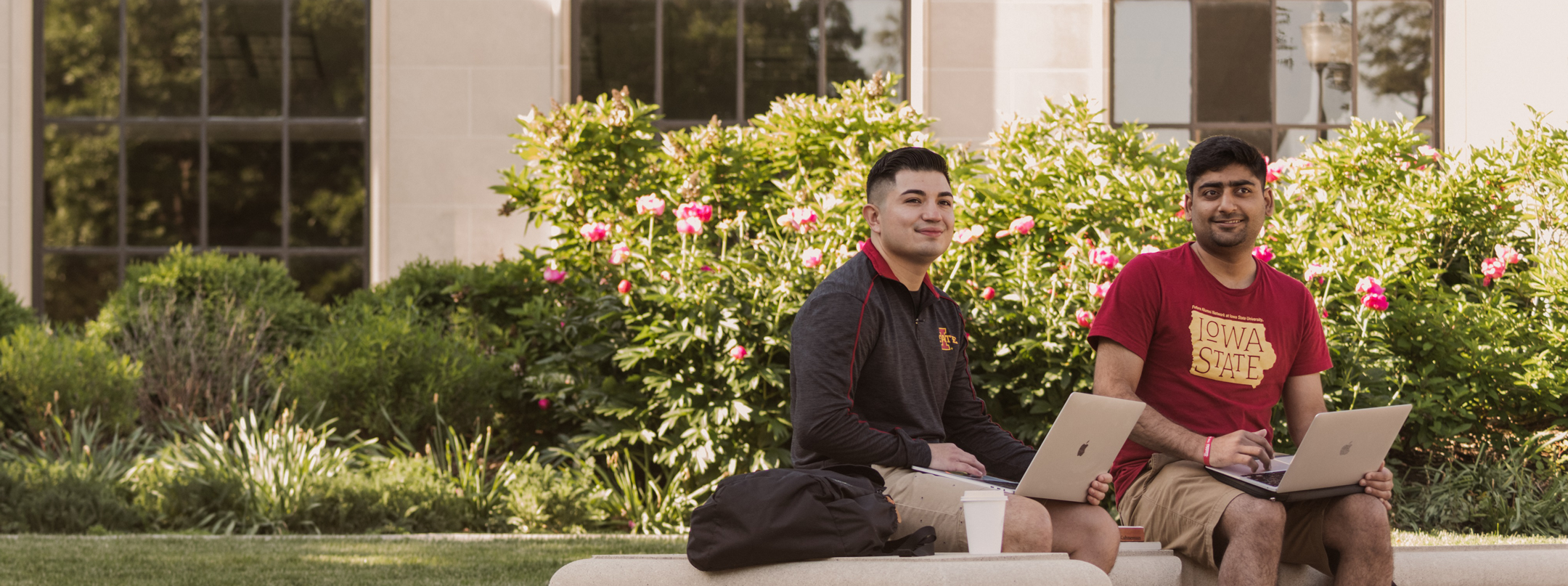 Two students on their computers by the Four Seasons Fountain