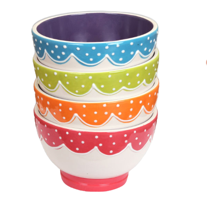 Four small bowls stacked inside each other with white base and different color decorations (red, orange, green, blue from top to bottom)