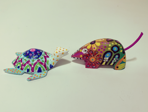 two alebrije painted with colorful patterns and designs