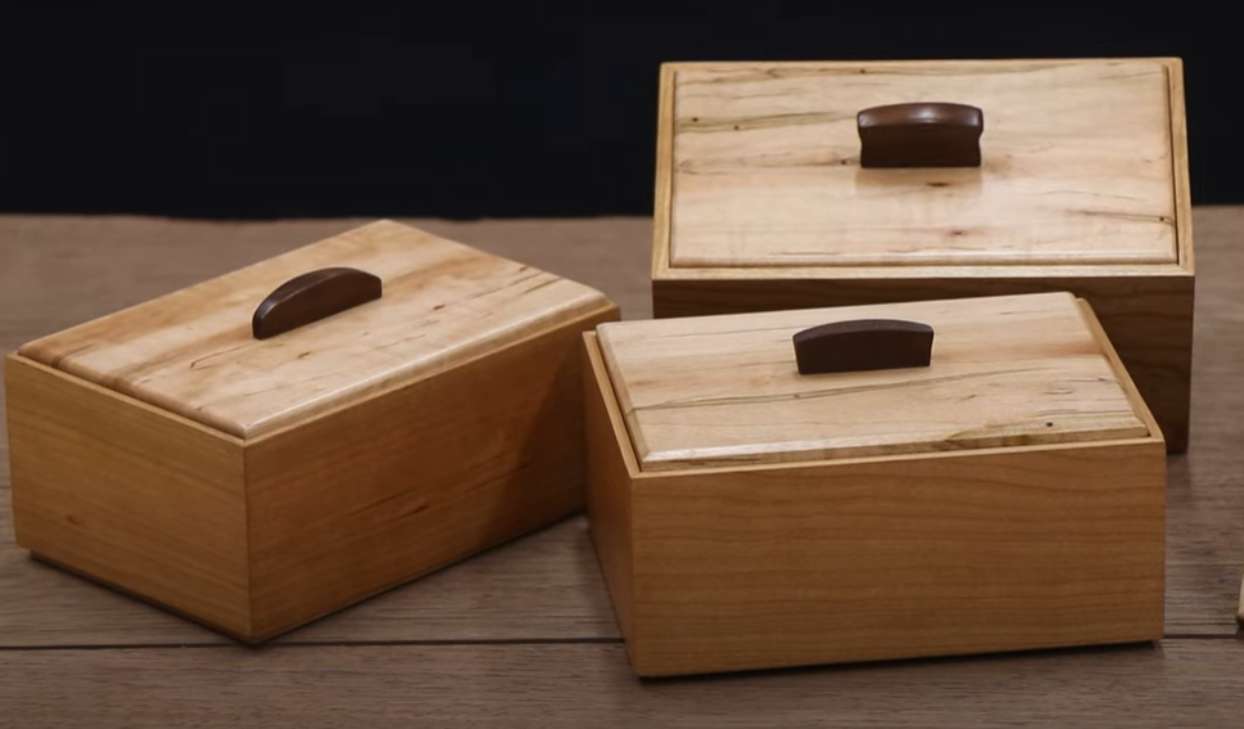 three wooden boxes with small handles on the lids