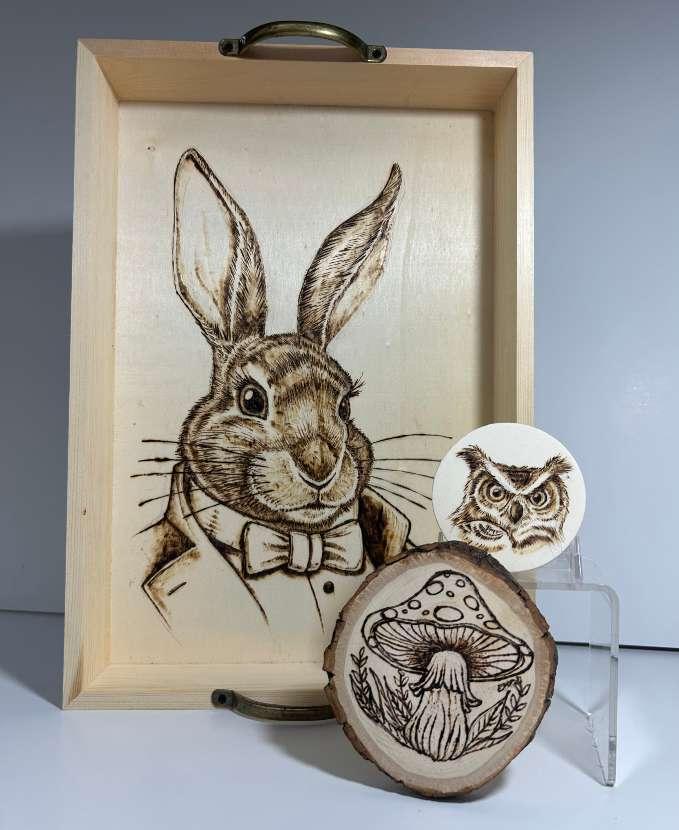 woodburned items with animals and a mushroom illustrated on them
