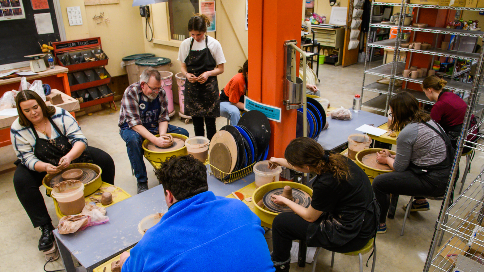 Greg Lamont instructing a grou pof students at the pottery wheels.